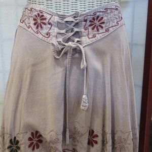 Fringe skirt with embroidered flowers. Elastic in back on waist, tie front.